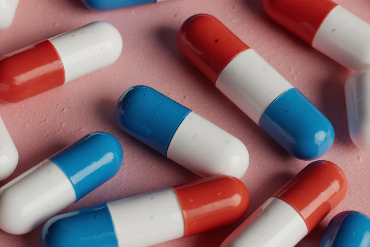 Close-up of colorful pharmaceutical capsules in red, blue, and white, symbolizing biotech and modern medicine.